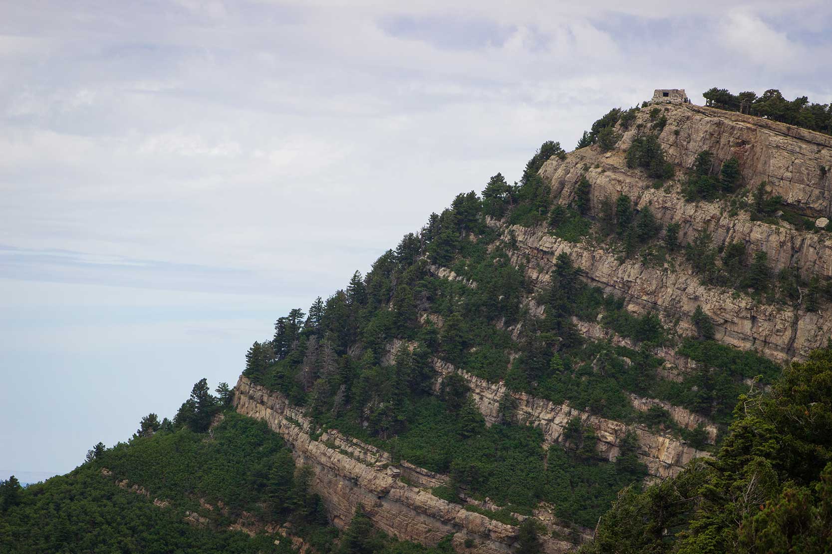 A cabin sits atop a mountain