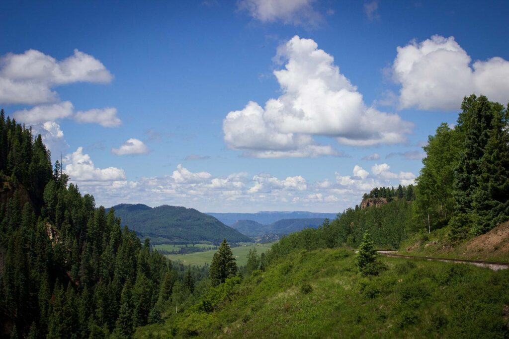 A mountain valley with a blue sky and some white clouds