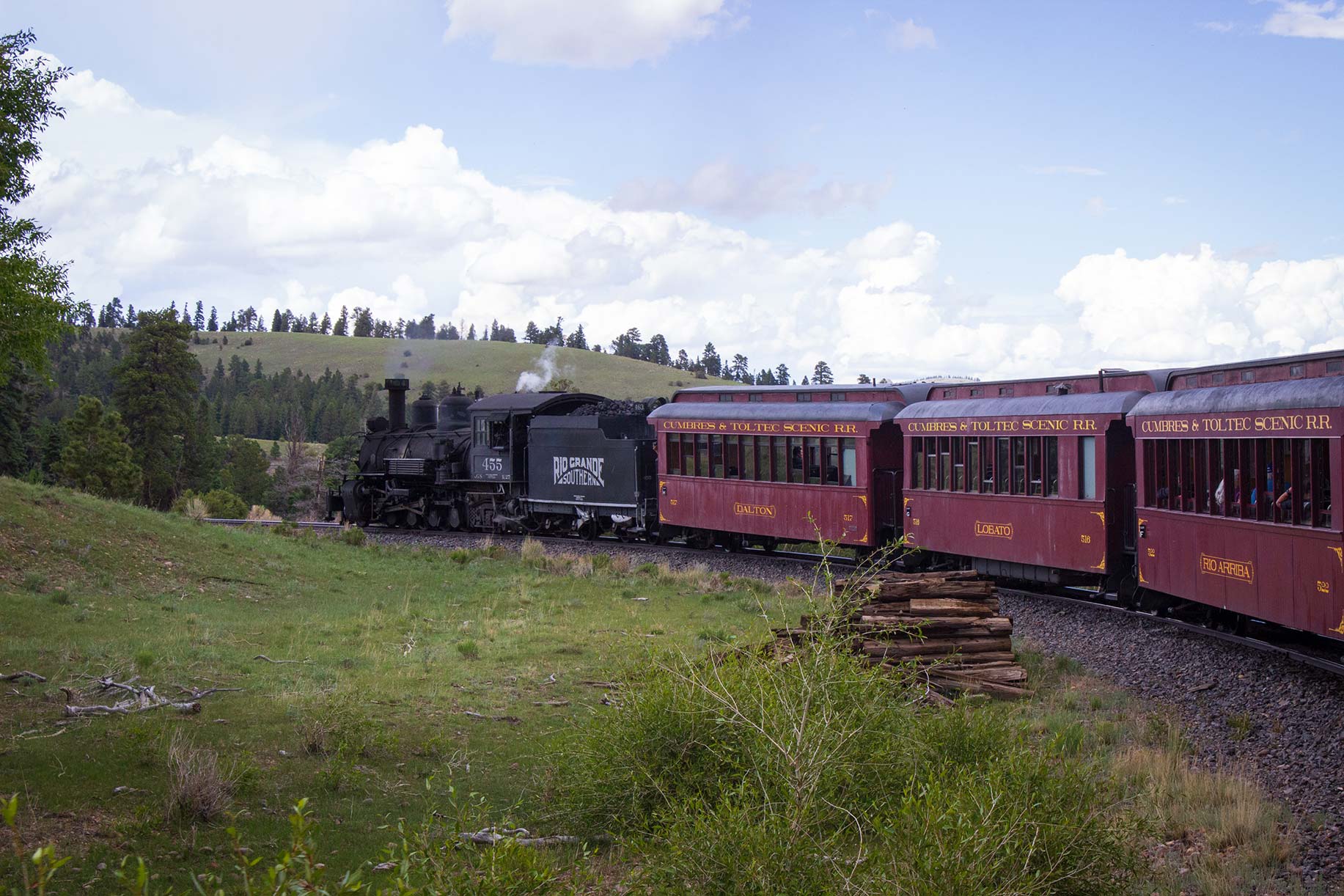 A steam engine leading a train in the mountains