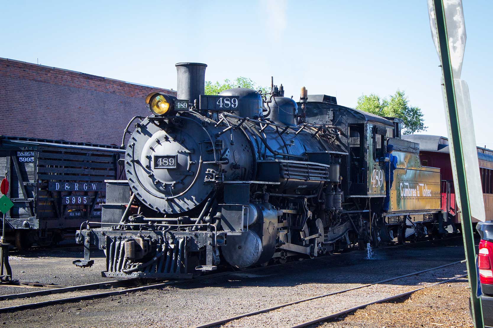 A steam train sits in a train yard