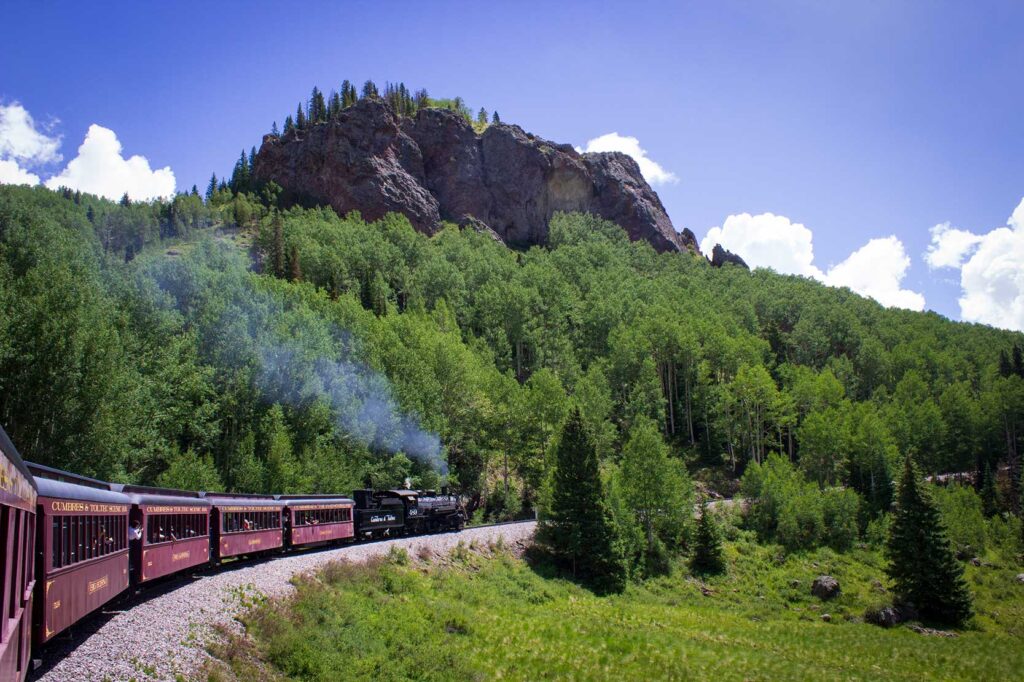 A train traveling along tracks in a mountain area