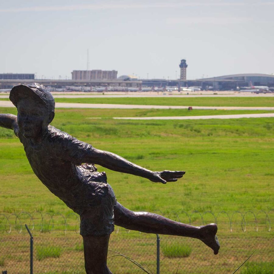A statue of a boy near an airport