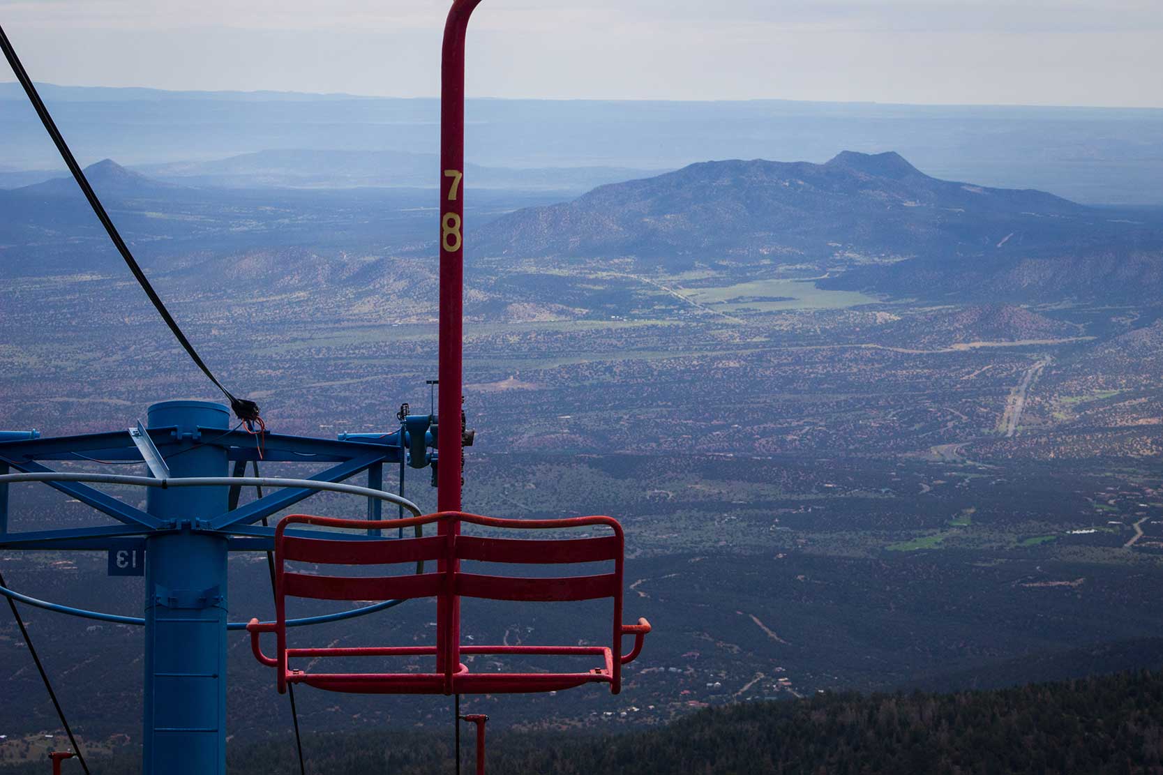 A chairlift sits still on the side of a mountain