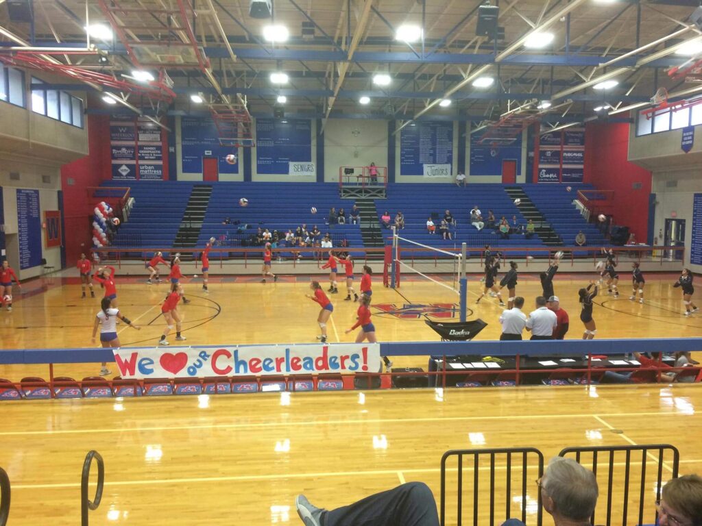 Two volleyball teams warm up before a game at Austin Westlake high school